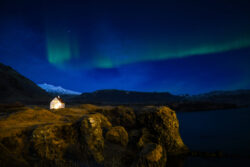 Single Icelandic home on sea cliff with faint aurora arc 14 dsc 0128