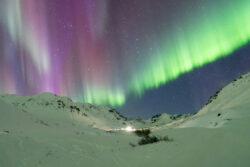 Multi colored aurora curtain over small village in Alaskan valley 2 dsc 3972