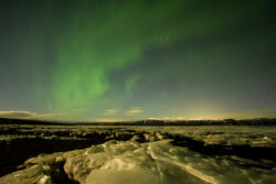 Faint aurora arc over partially frozen bay at low tide 20 dsc 0082