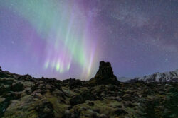 Aurora, Milky Way, and Andromeda Galaxy over Icelandic Lava Field #1 Purple and green aurora borealis over a rocky volcanic landscape Iceland Northern Lights